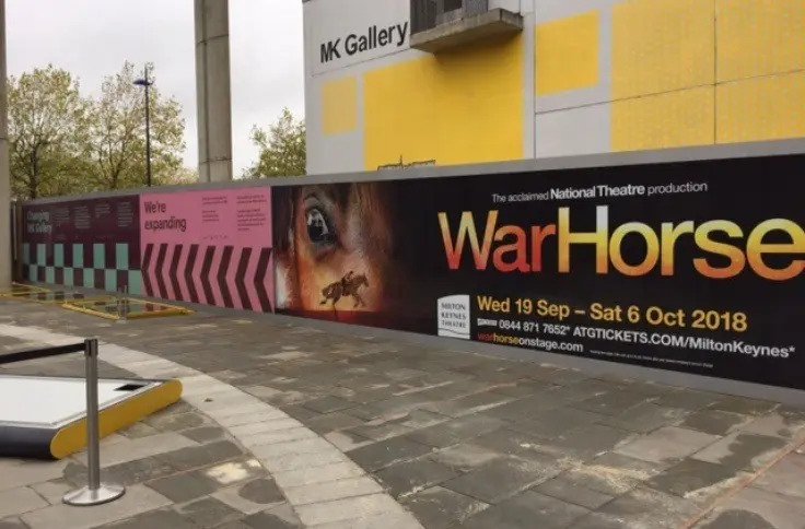 A photo of Custom printed hoarding graphics for MK Gallery with WarHorse advertisement