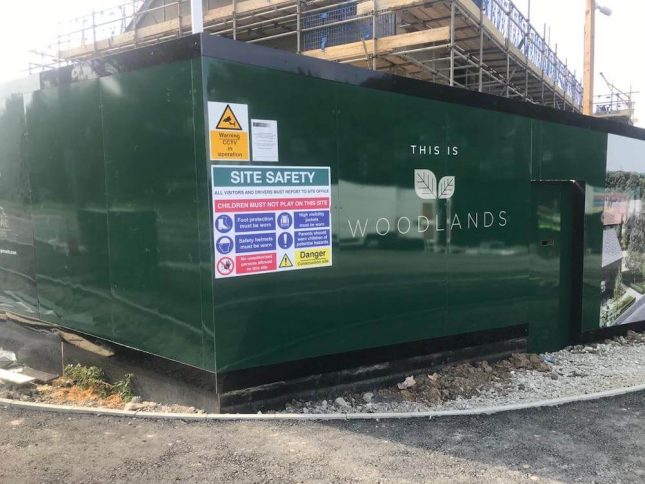 A photo of hoarding printing for This Is Woodlands